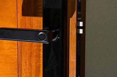 Fechadura digital com biometria e marca Kuanttum em porta de madeira